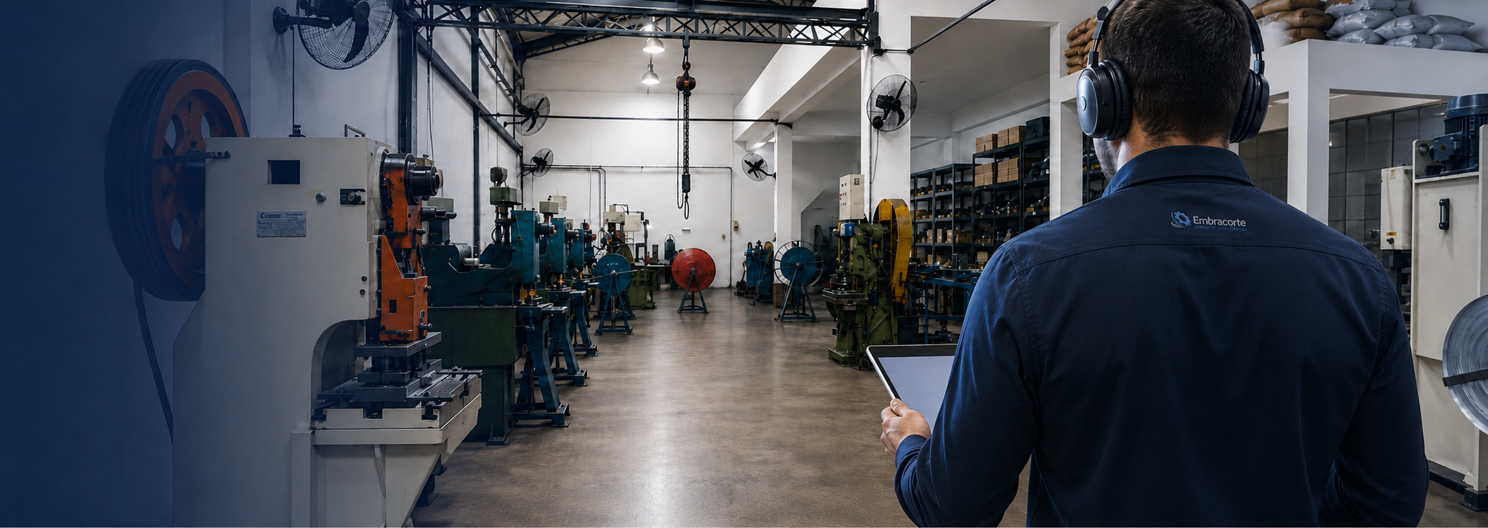 Consultor técnico da Embracorte com headset e tablet no salão industrial da empresa